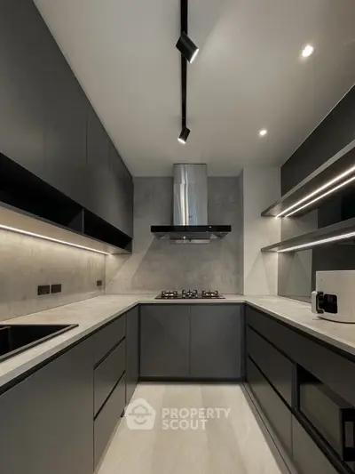 Modern kitchen with sleek black cabinetry and gas stove in a contemporary home.