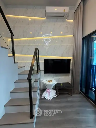 Modern duplex living room with stylish staircase and wall-mounted TV