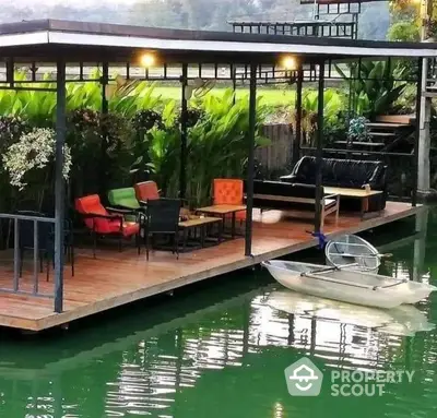 Charming waterfront deck with cozy seating and lush greenery, perfect for relaxation and enjoying serene views.