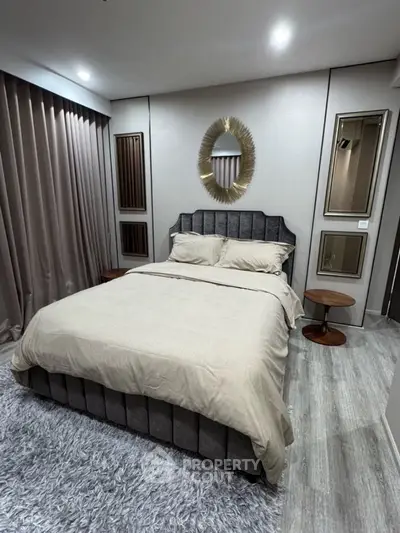 Luxurious bedroom with elegant decor and plush bedding in modern apartment.