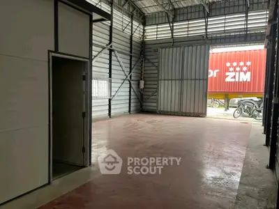 Spacious industrial warehouse with high ceilings and large sliding door access.