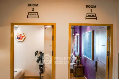 Modern interior with two bedroom entrances, stylish decor and vibrant wall art.