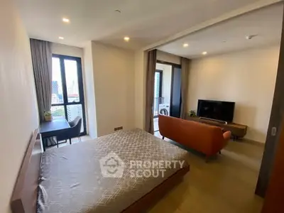 Modern studio apartment with open layout, featuring a cozy living area and a scenic city view from the balcony.