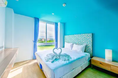Bright and airy bedroom with modern decor and large window view.