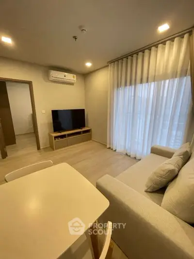 Modern living room with cozy sofa, TV, and dining area in stylish apartment