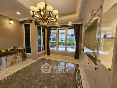 Luxurious living room with elegant chandelier and marble flooring, featuring large windows and built-in storage.