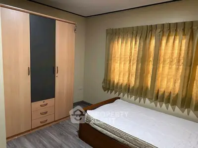 Cozy bedroom with wooden wardrobe and single bed, perfect for minimalist living.