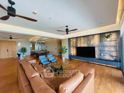 Luxurious living room with modern decor, leather sofa, and entertainment center.