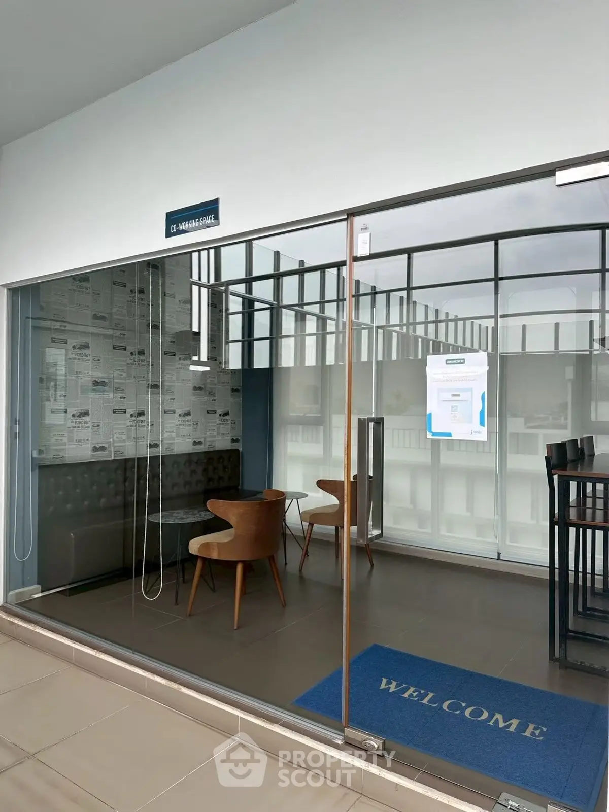 Modern office entrance with glass walls and stylish seating area
