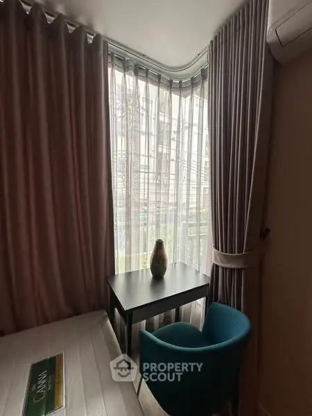 Cozy corner room with elegant curtains and modern furniture, perfect for a serene workspace.