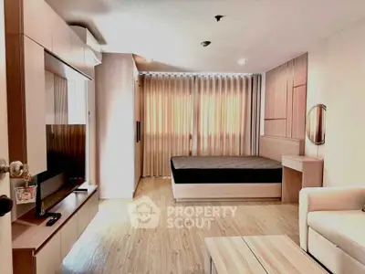 Modern studio apartment with wooden flooring and stylish furnishings, featuring a cozy bed and sleek entertainment unit.