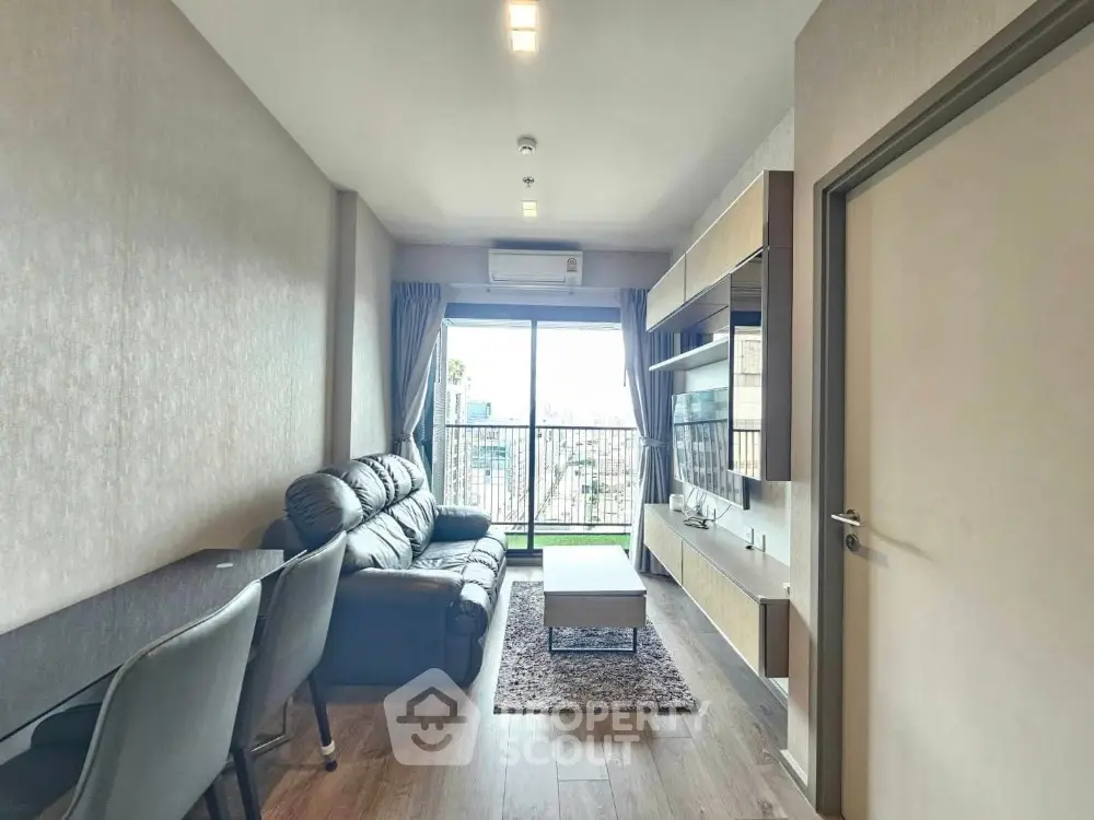 Modern living room with balcony view, stylish furniture, and ample natural light.