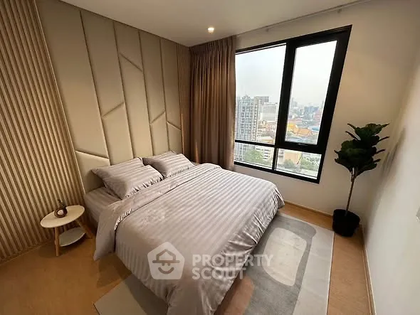 Modern bedroom with city view, featuring elegant decor and large window.