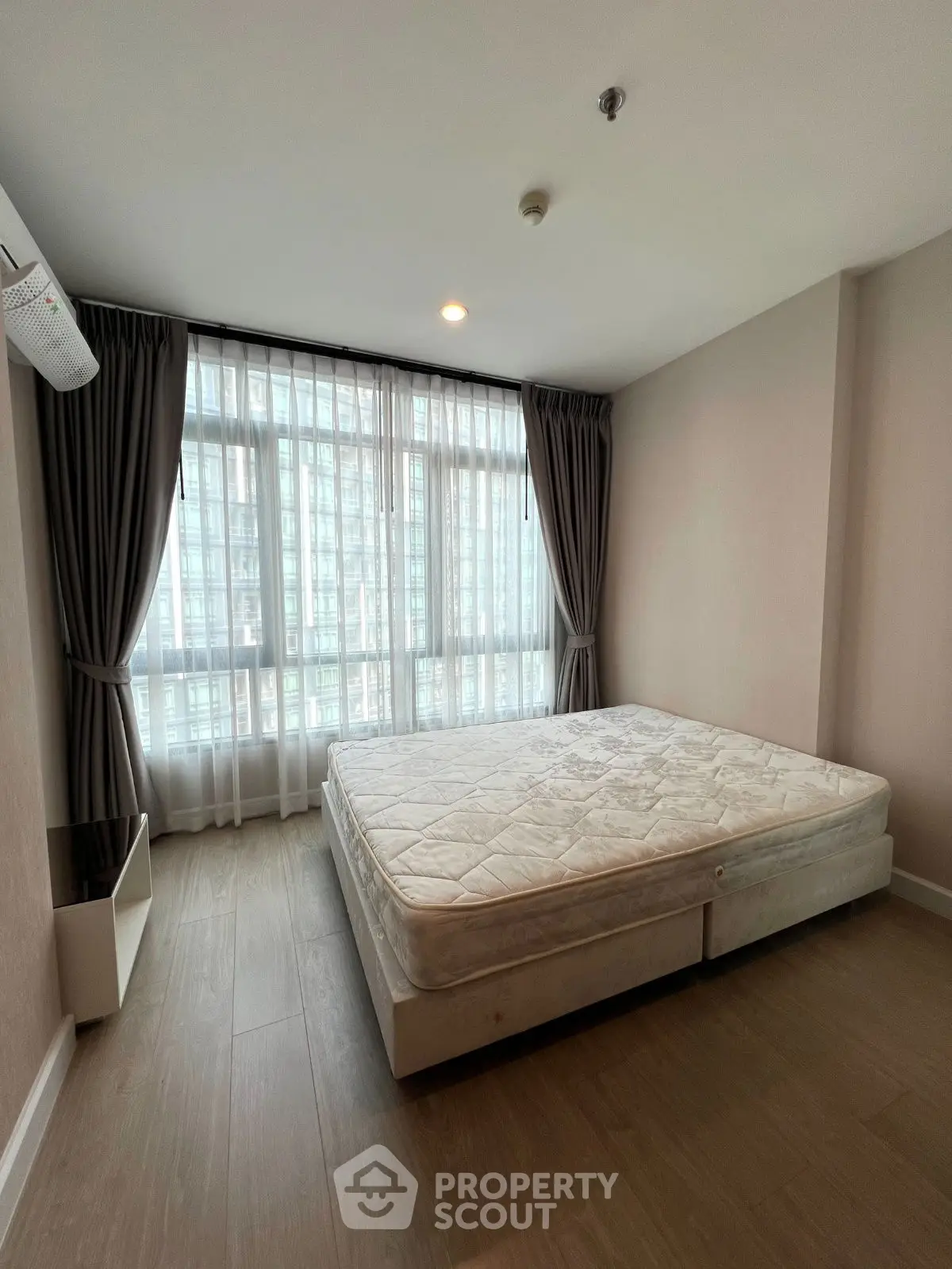 Spacious bedroom with large windows and natural light in modern apartment
