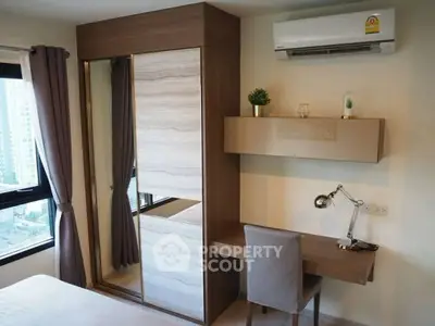 Modern bedroom with built-in wardrobe and study desk, featuring city view.