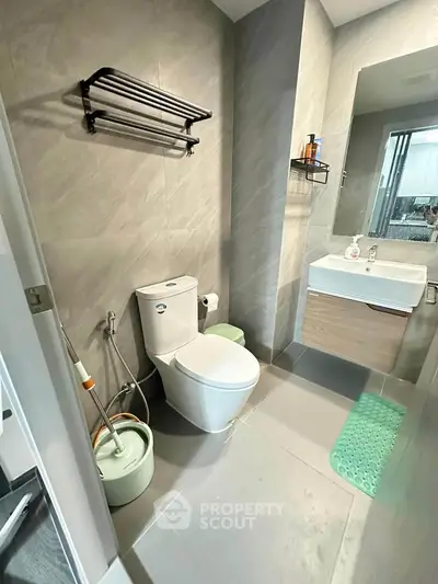 Modern bathroom with sleek fixtures and contemporary design, featuring a wall-mounted sink and stylish tile flooring.