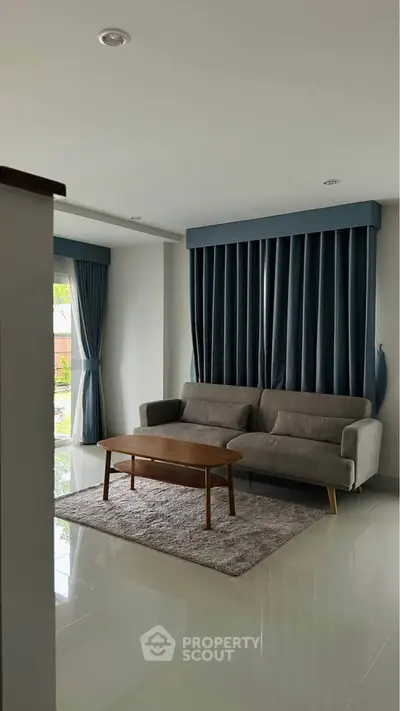 Modern living room with sleek sofa and elegant curtains, perfect for stylish urban living.