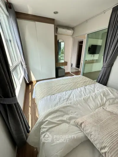 Bright and cozy bedroom with large windows and modern decor in a stylish apartment.