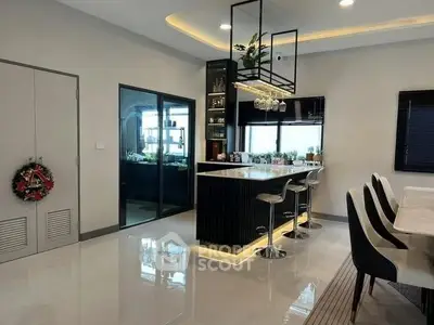 Modern kitchen with sleek island and stylish bar stools in elegant home.