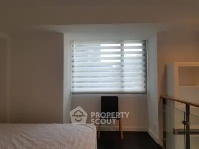Modern bedroom with minimalist decor and large window with blinds