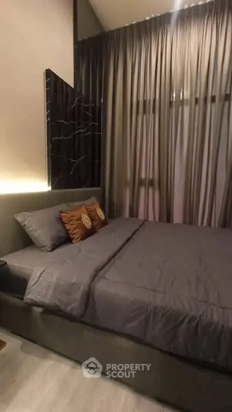 Cozy bedroom with elegant decor and soft lighting, featuring a comfortable bed and stylish curtains.