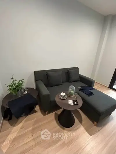 Modern living room with stylish dark sofa and wooden flooring
