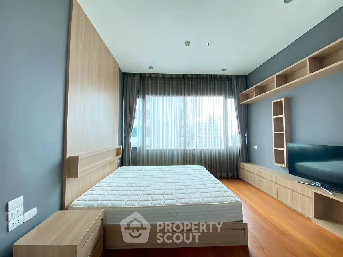Modern bedroom with large window and wooden furniture in urban apartment