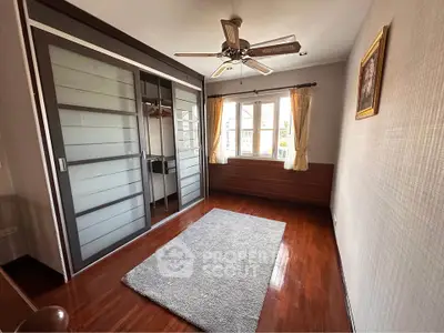 Spacious bedroom with wooden flooring and large wardrobe in modern apartment