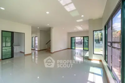 Spacious modern living room with large windows and glossy tiled floors