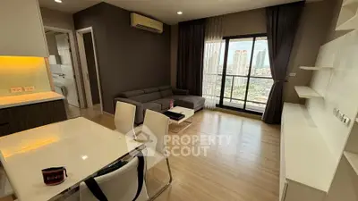 Modern living room with city view, featuring sleek furniture and open layout.