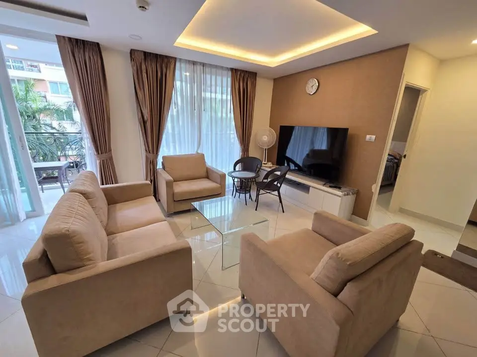 Spacious modern living room with elegant furniture and large windows offering natural light.