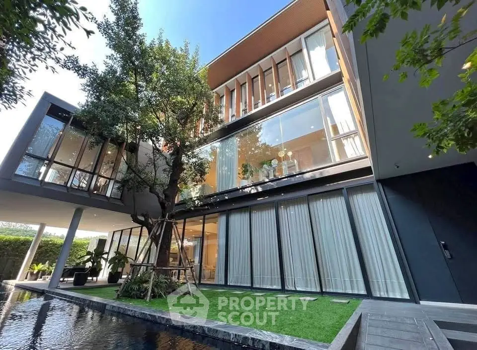 Luxurious modern home exterior with large windows and lush garden view