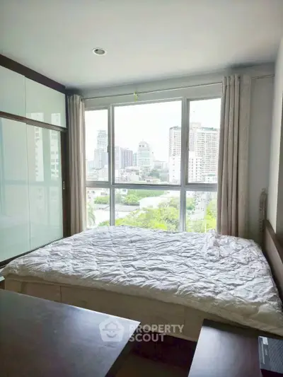 Modern bedroom with large window offering stunning city view