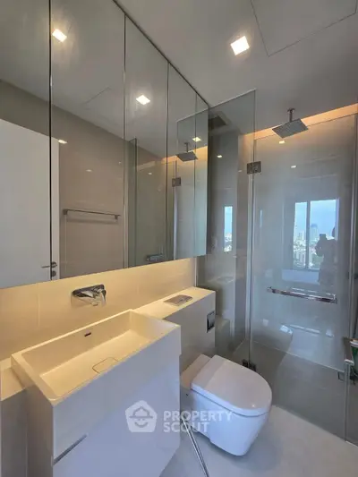 Modern bathroom with sleek fixtures and city view from glass shower enclosure.