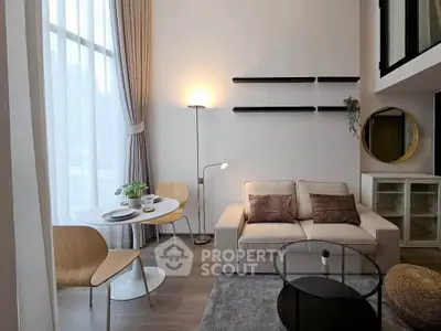 Modern living room with high ceilings, cozy sofa, and stylish dining area in open-plan apartment.