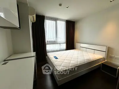 Modern bedroom with large window and minimalist furniture in a stylish apartment.