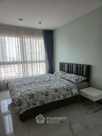 Modern bedroom with large window and stylish decor in a high-rise apartment.