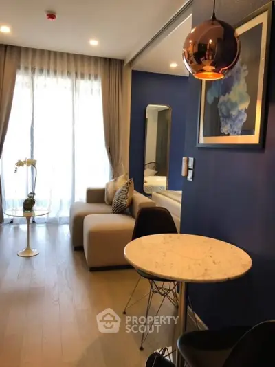 Modern living room with elegant decor and natural light, featuring a cozy sofa and stylish lighting.