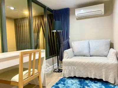 Cozy living room with modern decor, featuring a plush sofa, stylish floor lamp, and air conditioning.