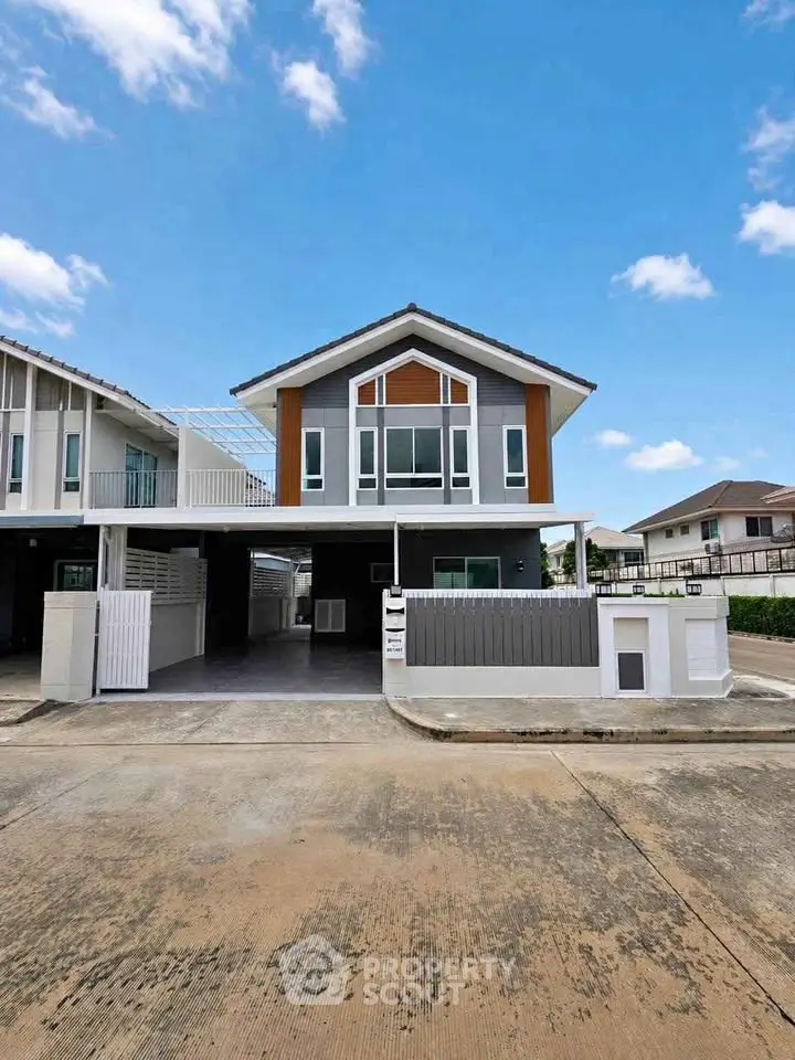 Modern two-story house with a spacious driveway and contemporary design in a suburban neighborhood.