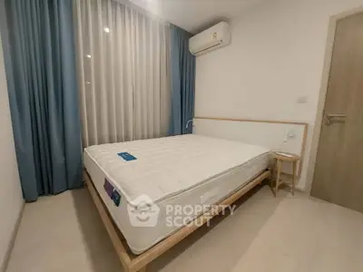 Modern bedroom with minimalist design featuring a comfortable bed and air conditioning.