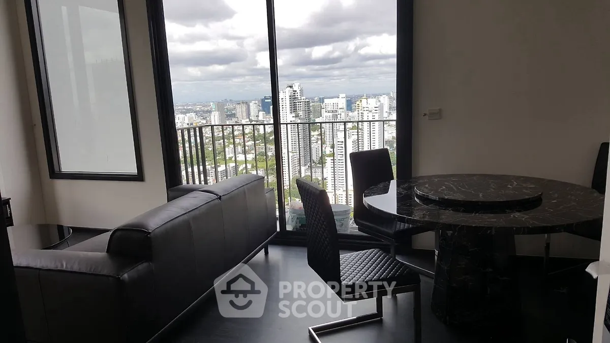 Modern living room with stunning city view from high-rise balcony.