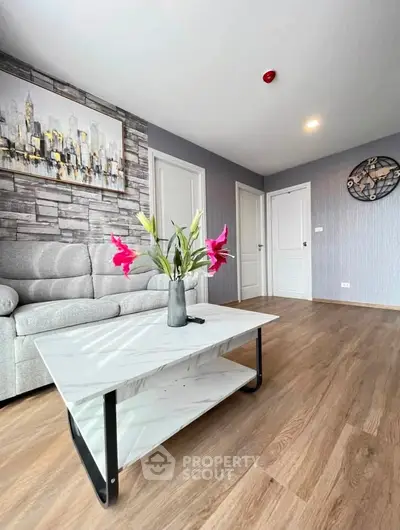 Modern living room with stylish decor and wooden flooring, featuring a cozy sofa and elegant coffee table.