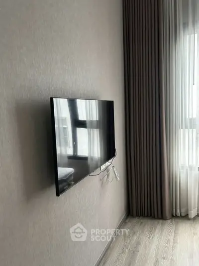 Modern living room with wall-mounted TV and elegant curtains