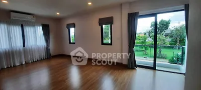 Spacious living room with large windows and garden view, perfect for natural light lovers.