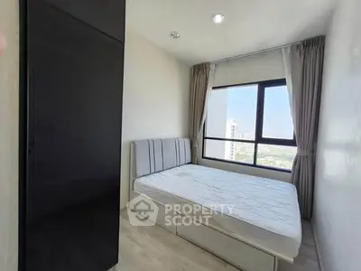 Modern bedroom with large window and sleek black wardrobe