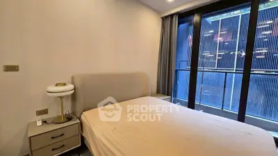 Modern bedroom with large windows and balcony access in urban apartment