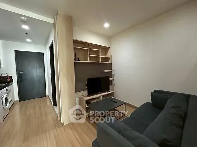 Modern living room with sleek furniture and built-in shelving in a cozy apartment.