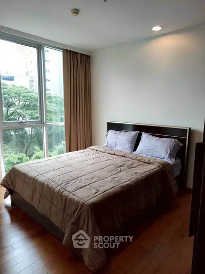 Cozy bedroom with large window and scenic view in modern apartment