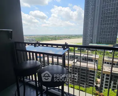 Stunning high-rise balcony with river view and modern seating, perfect for relaxation.
